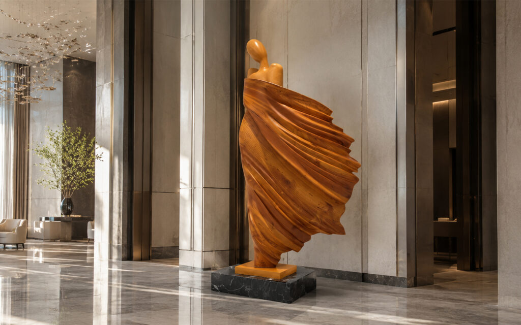 Sculpture monumentale en bois représentant une silhouette drapée installée dans le hall élégant d’un hôtel